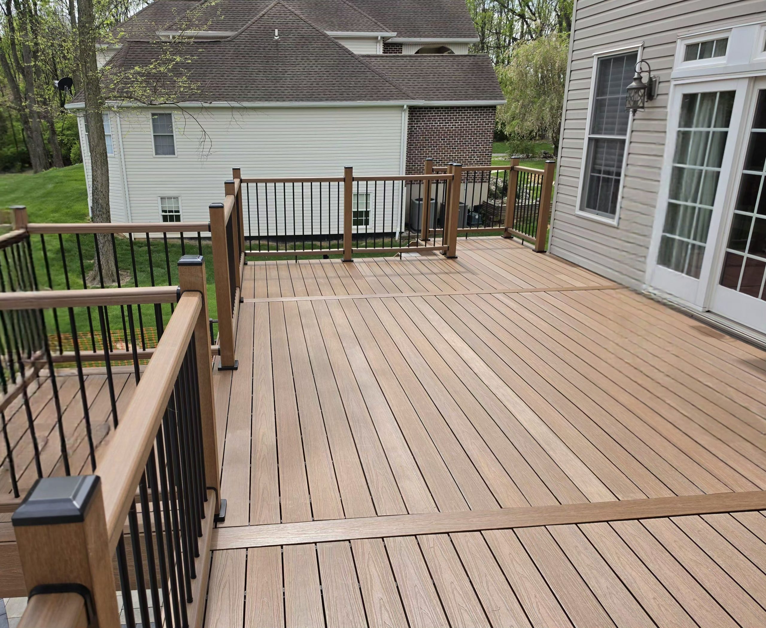 Large composite deck with bronze railing wrapping the rear of a Central Pennsylvania home — TrueCraft Decking