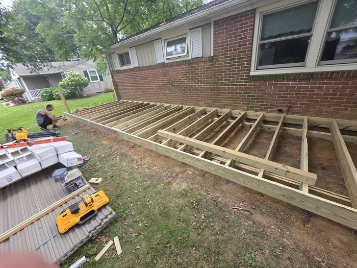 Pressure-treated joists being installed on a low-level freestanding deck frame — Richland, PA