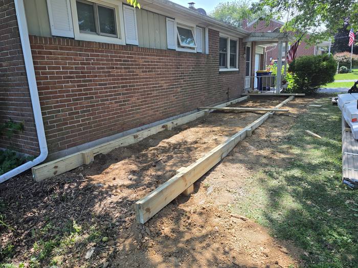 Beam set along the house with graded soil ready for framing — Richland, PA deck build