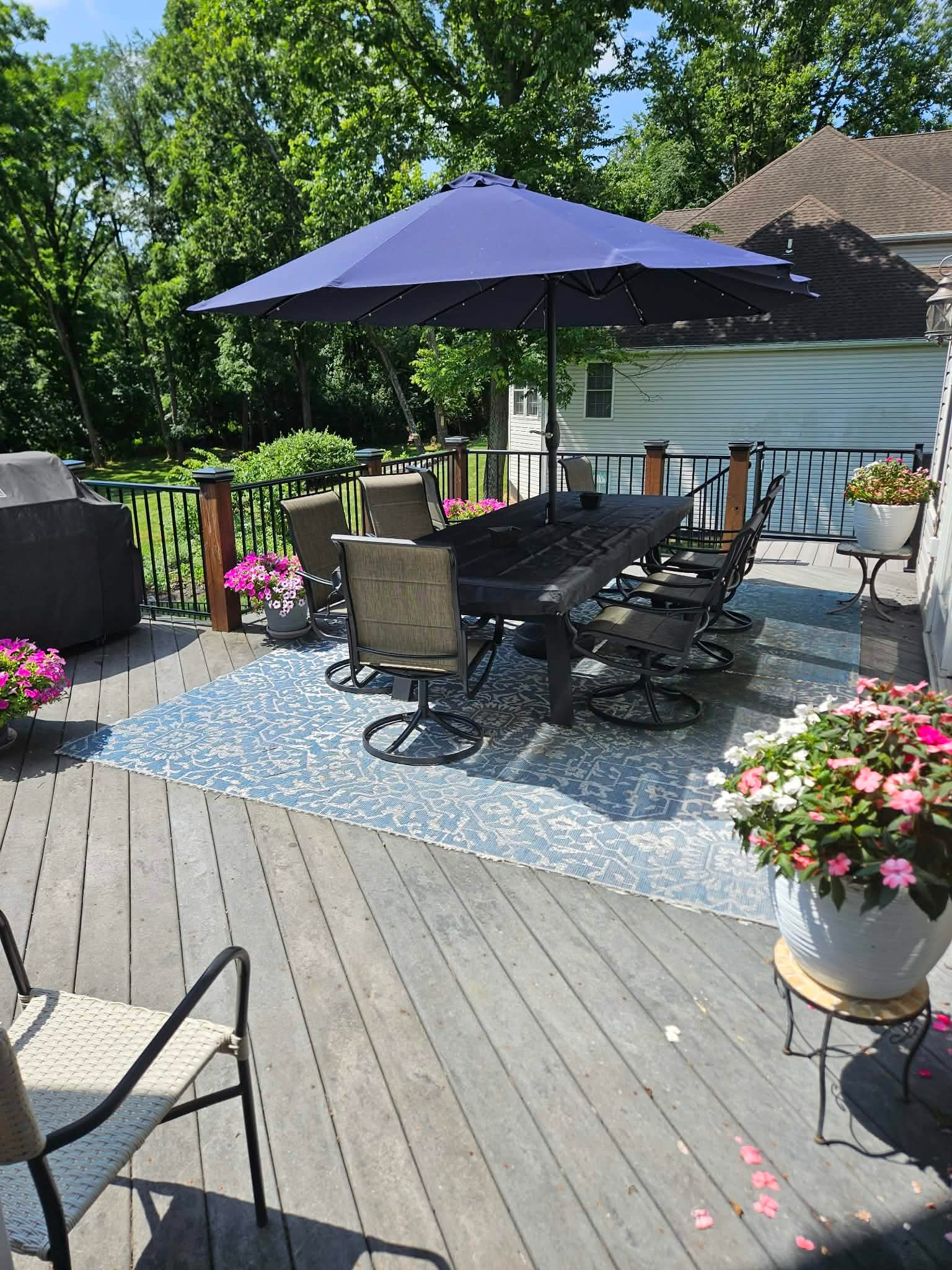 Elevated composite deck with black metal railing, patio furniture and planters — Central Pennsylvania
