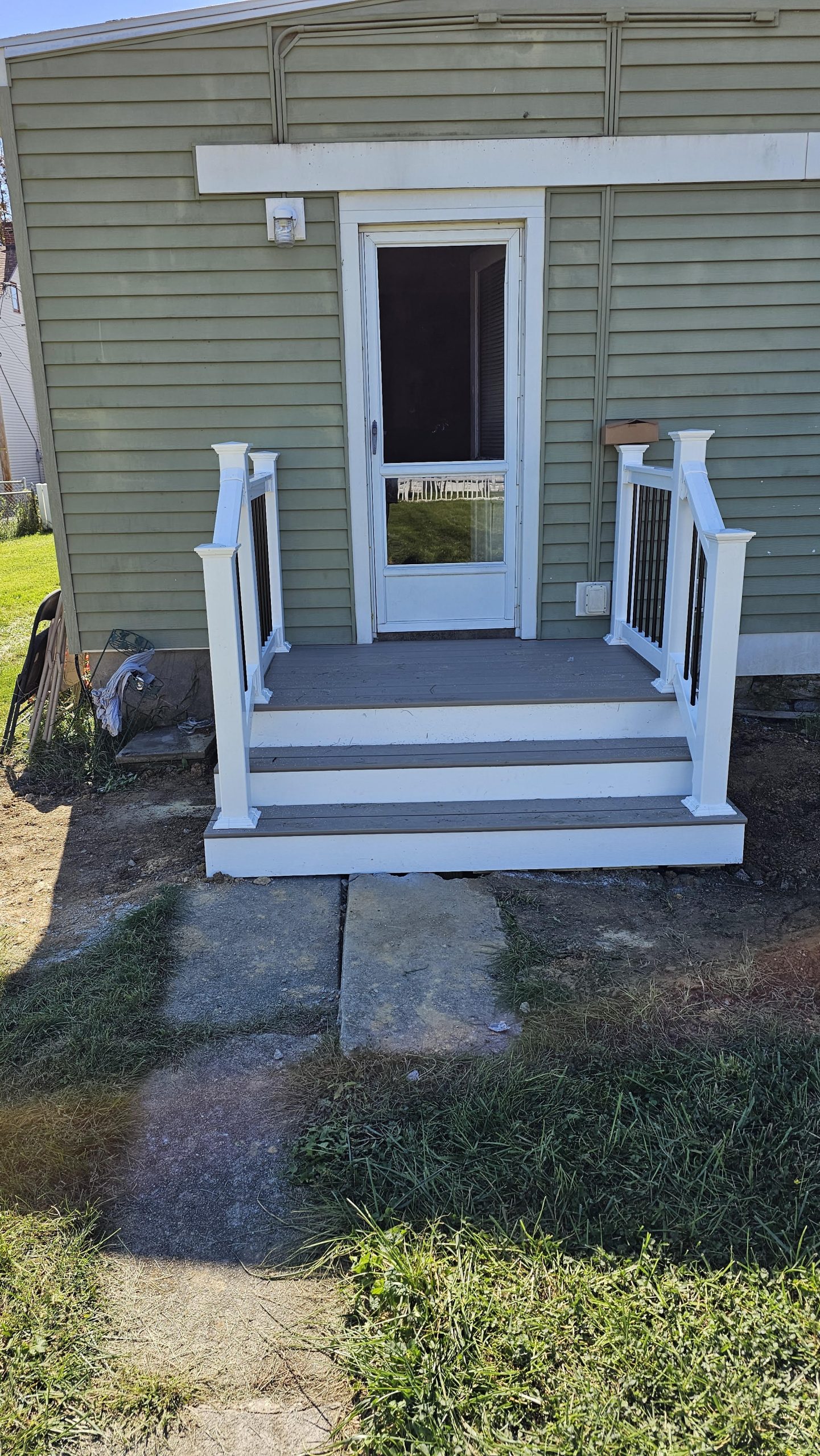 New deck landing and steps with white railing replacing a concrete stoop — Central Pennsylvania